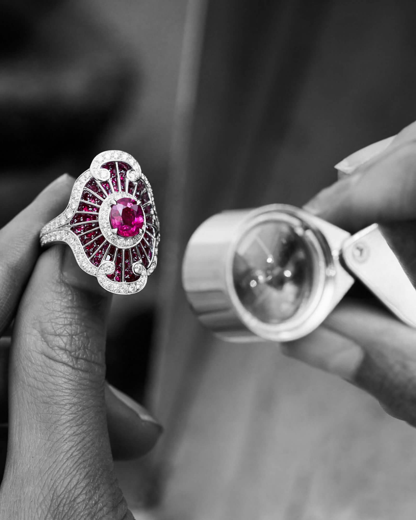 a Garrard gemmologist looking at a ruby jacket ring through a loupe