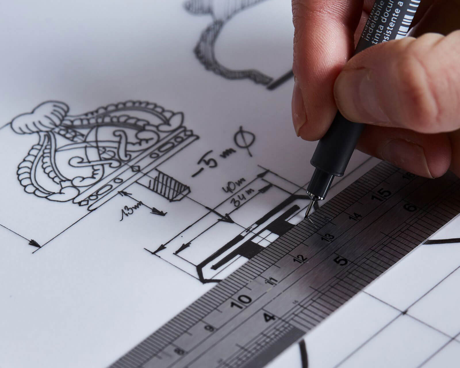 a Garrard designer sketching a technical drawing of a new silver trophy desktop