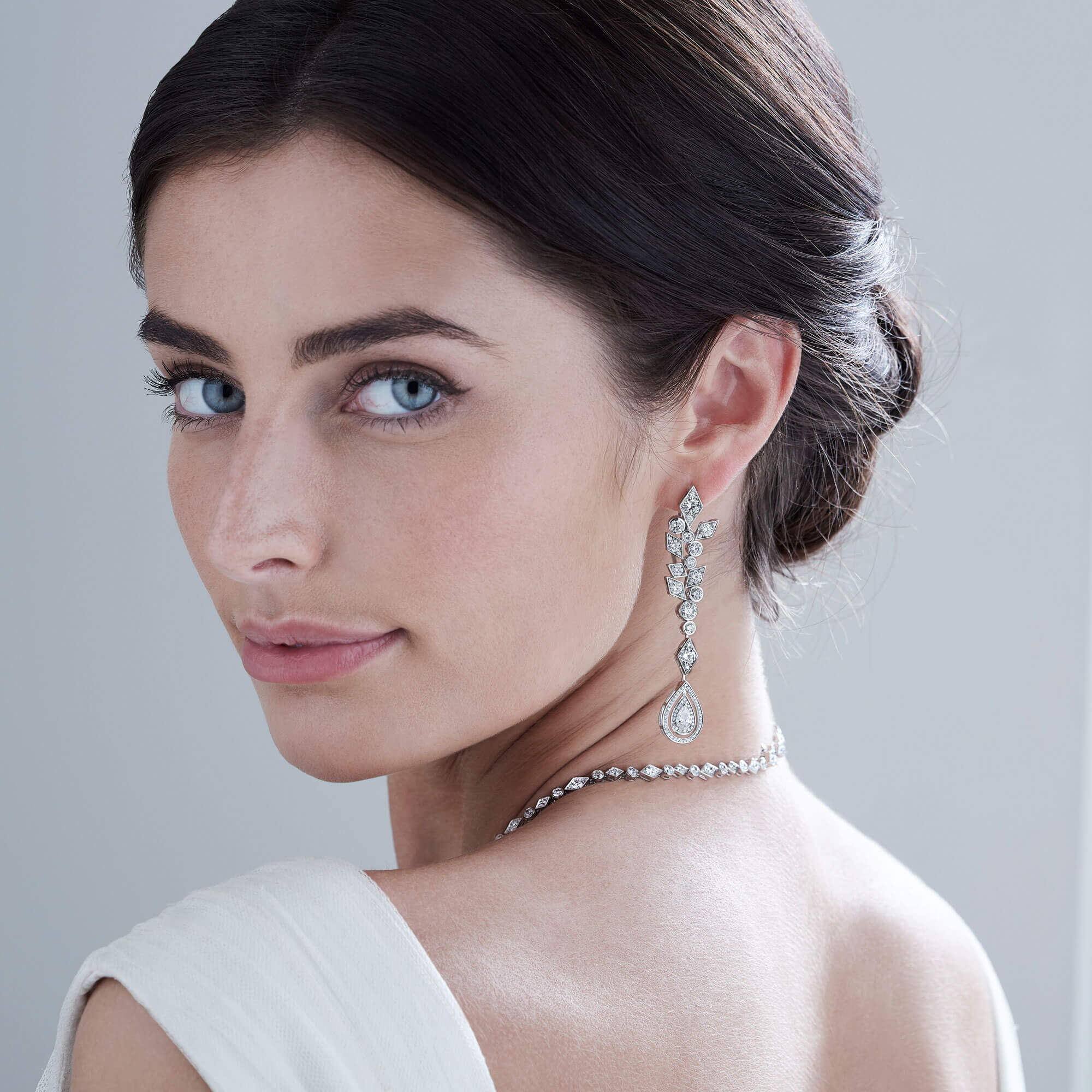 Close up of a bride wearing Garrard Bridal collection diamond necklace and earrings square