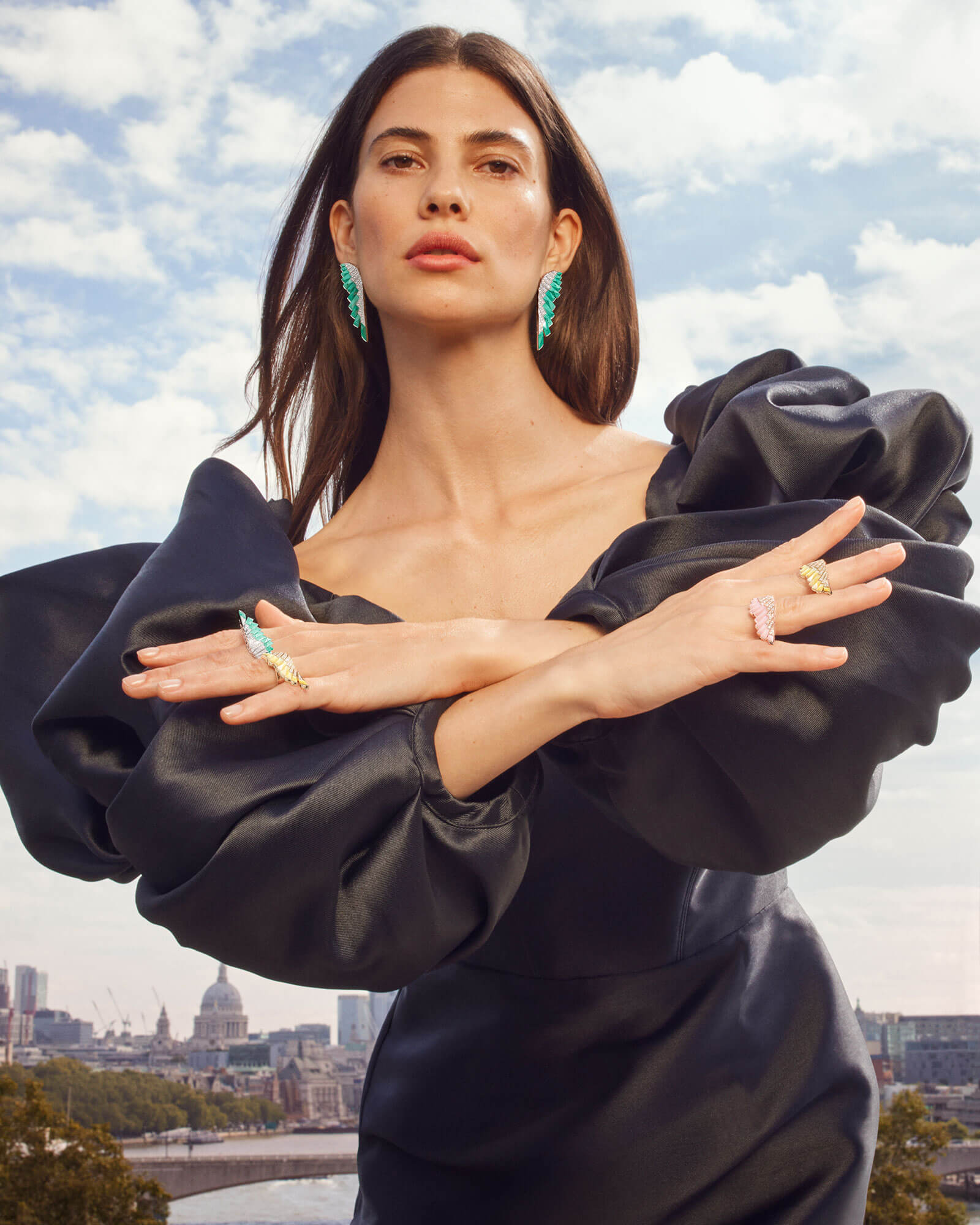 Model wears Garrard brand new Wings Rising collection earrings and rings with London skyline in the background