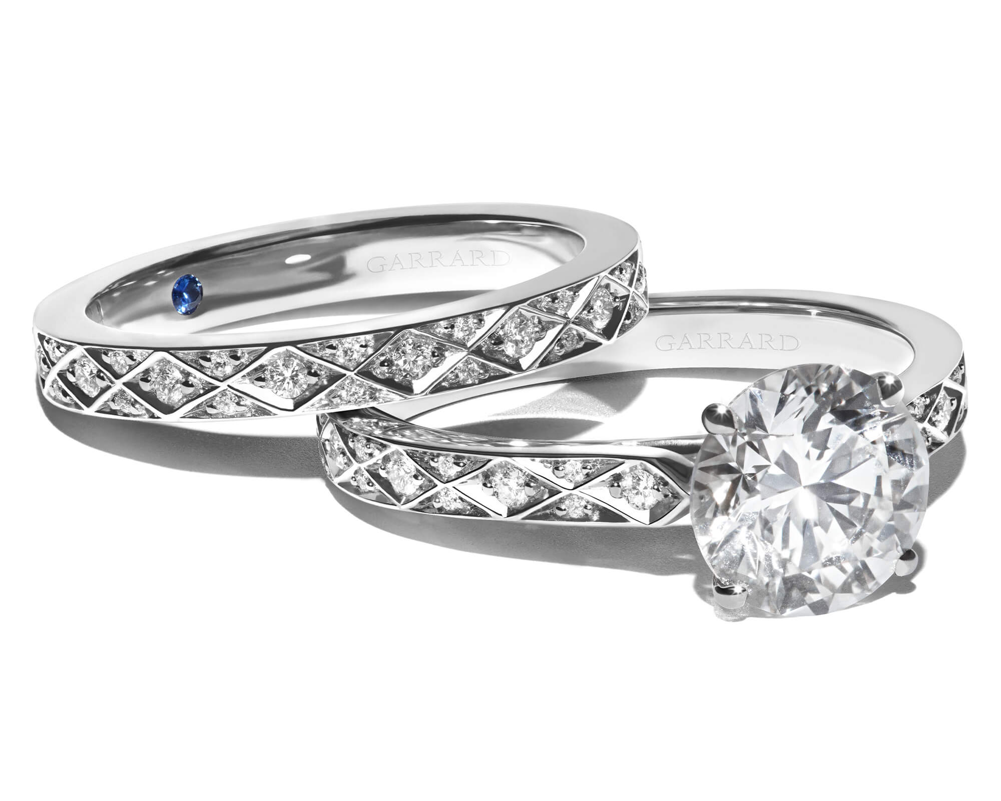 close up of a Garrard signature diamond engagement ring with signature diamond wedding bands