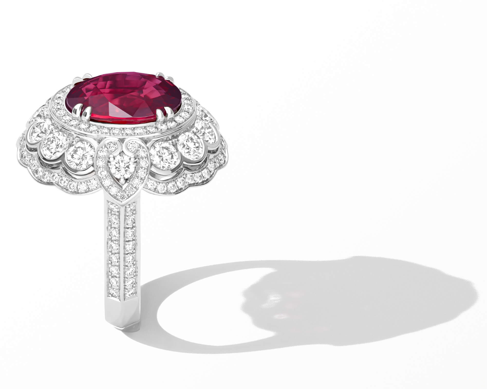 A Garrard Jewelled Vault ring set with a central oval ruby with a round white diamond surround adjusted