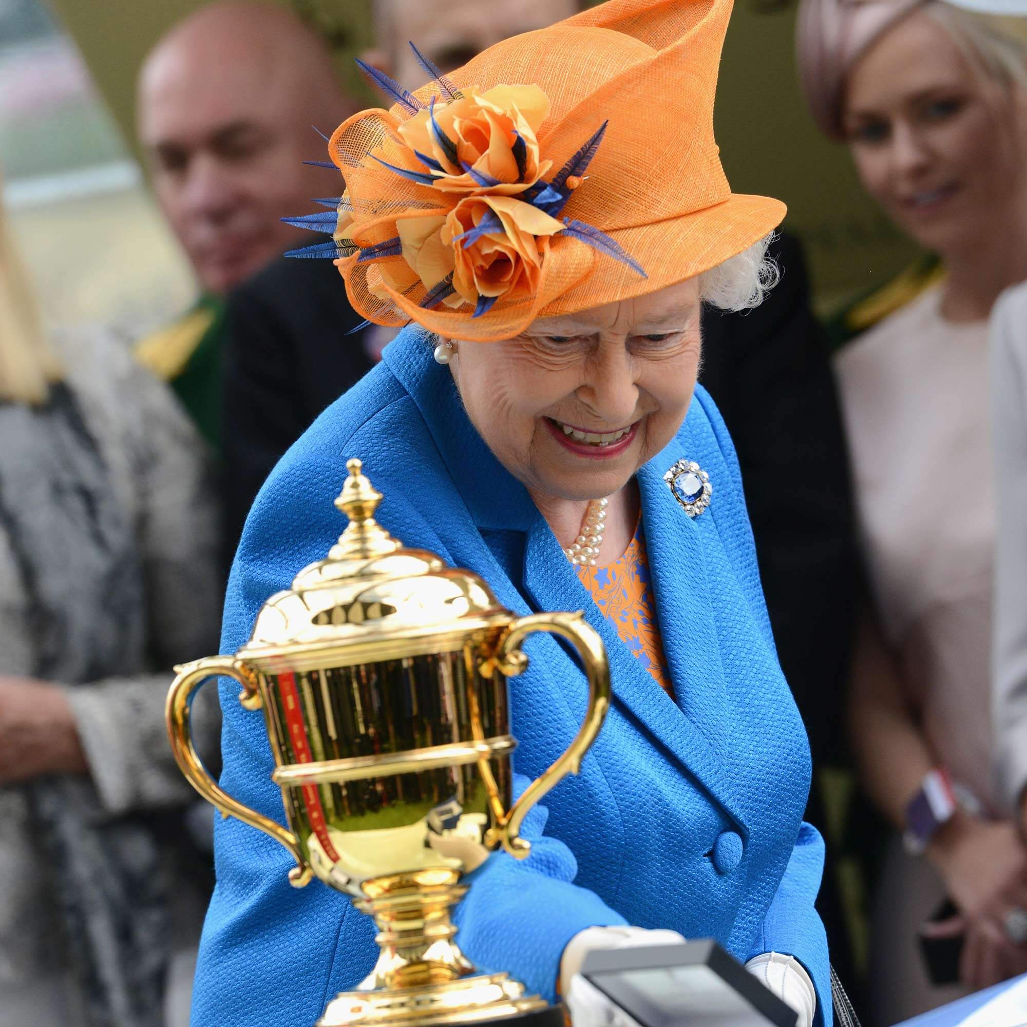 Queen Elizabeth II wears the Sapphire Brooches made by Garrard at the Royal Ascot with the Gold Cup also made by Garrard